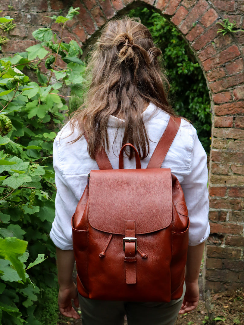 Large Leather Drawstring Backpack, unisex design available in Black, Dark Brown, Red, Burgundy, Navy, Black and Chestnut. Made in Ireland. Photo is shot in context on a model.